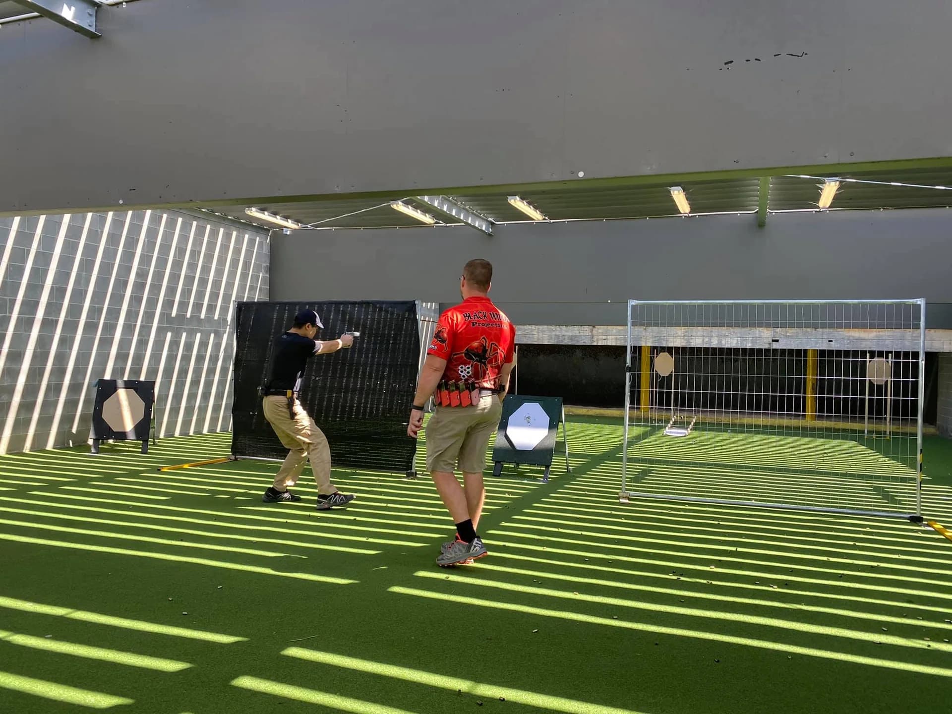 An instructor and participant in a practical Lorco Shooting Academy session.
